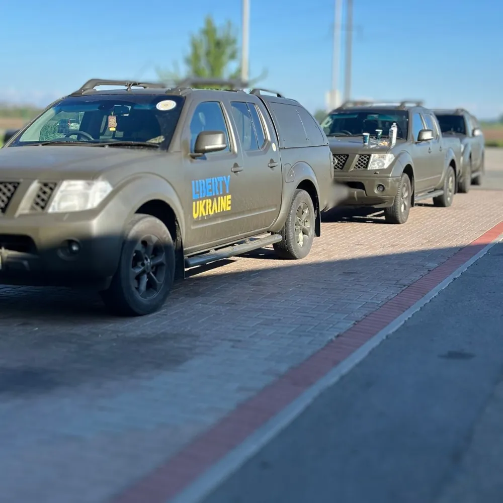 A convoy of khaki Liberty Ukraine evacuation pickups